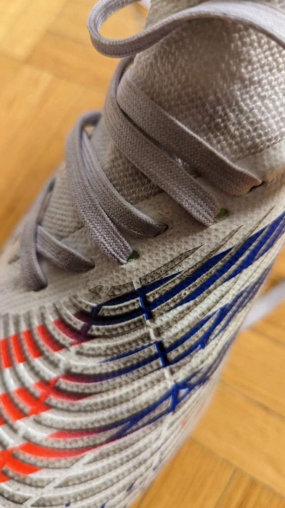 Chi tiết dây buộc bị xoắn trên đôi giày Predator Edge.3 turf màu trắng