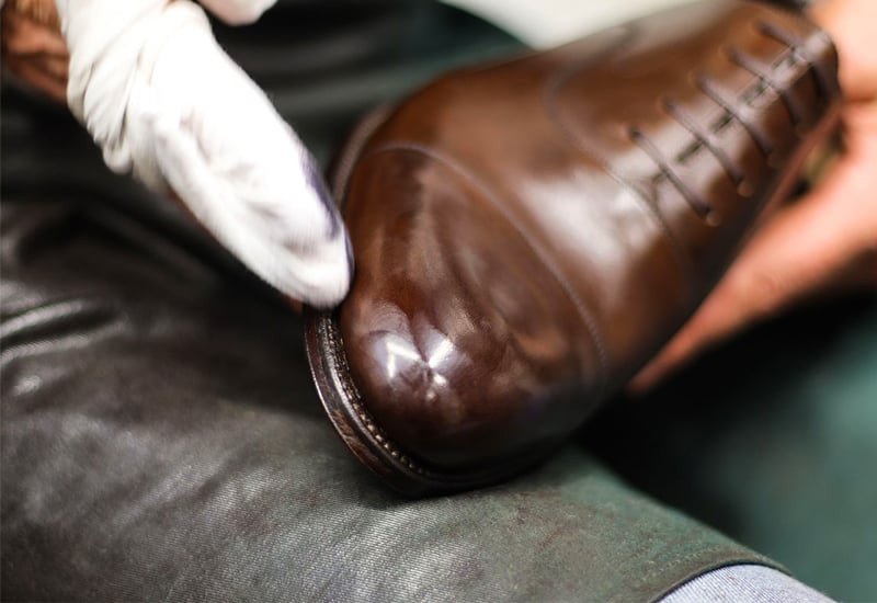 Đánh bóng giày da bóng bằng dầu khoáng và khăn mềm để đạt độ sáng hoàn hảo.