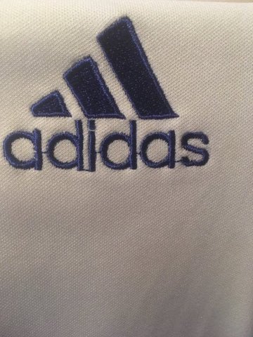 Dấu hiệu logo Adidas giả mạo với đường chỉ thừa
