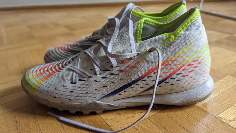 Hình ảnh mặt bên của giày Adidas Predator Edge 3 màu trắng đã qua sử dụng trên sân cỏ nhân tạo