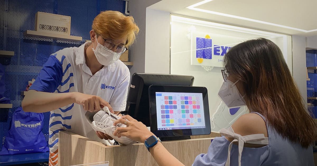 Một chuyên gia đang kiểm tra tỉ mỉ tình trạng tổng thể của đôi giày sneaker trước khi tiến hành dịch vụ vệ sinh giày sneaker.