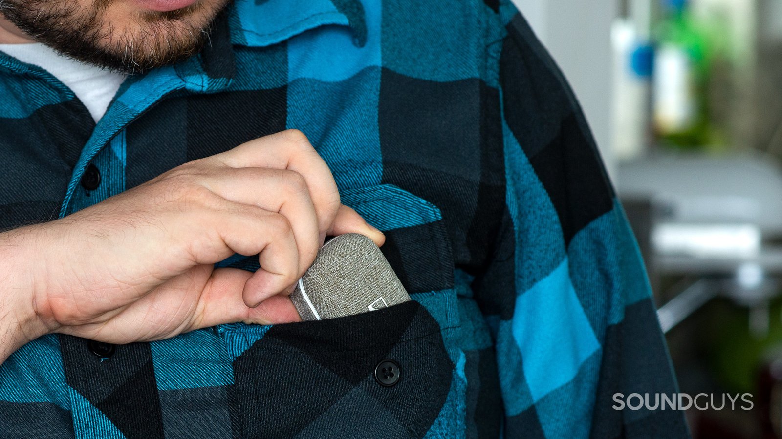 Một người đàn ông đang bỏ tai nghe Sennheiser Momentum True Wireless 2 vào túi áo, thể hiện tính di động của hộp sạc.