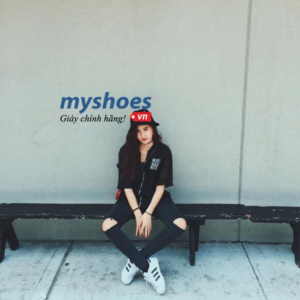 Một người đàn ông mặc áo phông trắng, quần jean đen và giày Adidas Superstar trắng, phong cách đơn giản