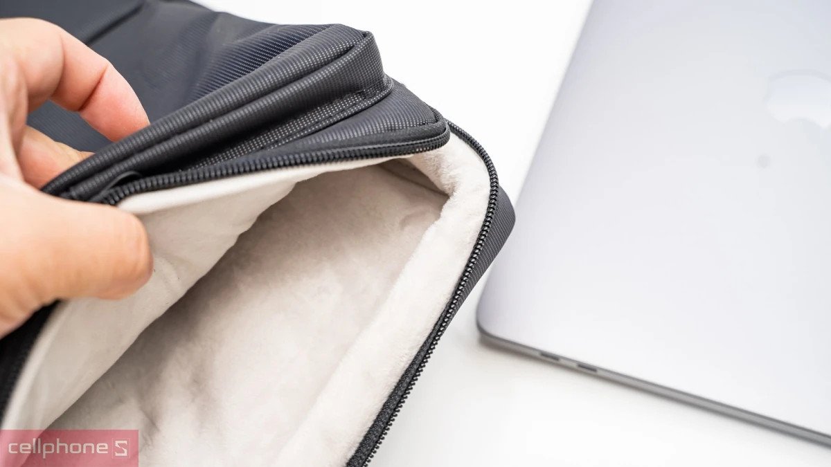 Một người phụ nữ đang đặt laptop 13 inch vào túi chống sốc vừa vặn