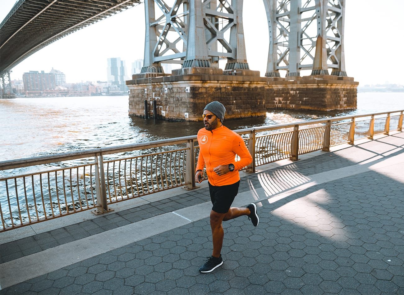 Người đàn ông mặc áo khoác adidas chạy bộ dưới trời tuyết, minh họa trang phục adidas nam mùa đông chính hãng