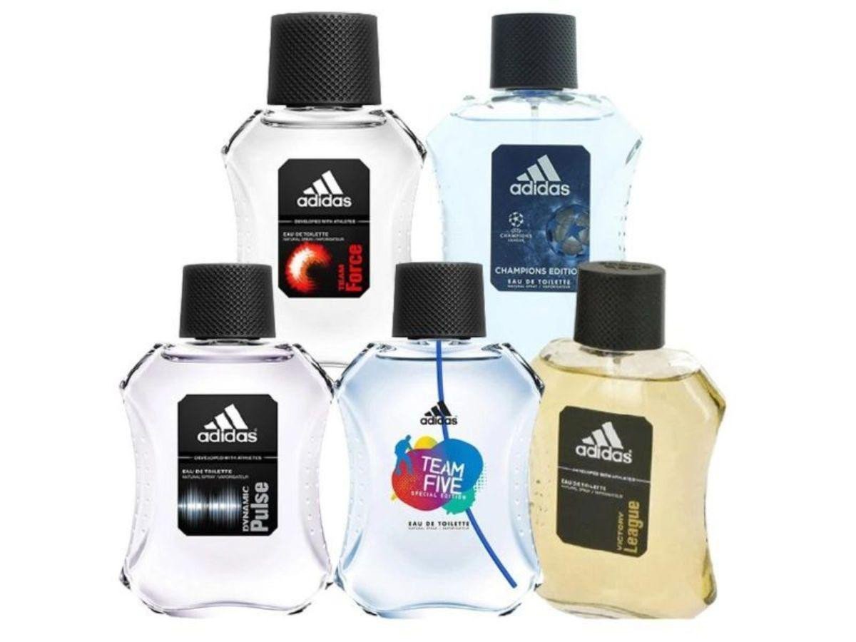 Người đàn ông tươi tắn với bình nước hoa Adidas trong tay, thể hiện sự năng động và phong cách thể thao