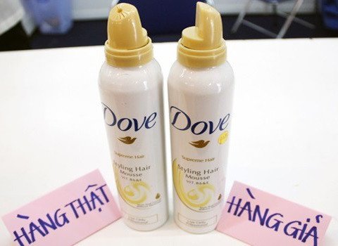 Người dùng đang cầm sản phẩm và quét mã vạch để kiểm tra thông tin, hỗ trợ cách phân biệt hàng thật hàng giả