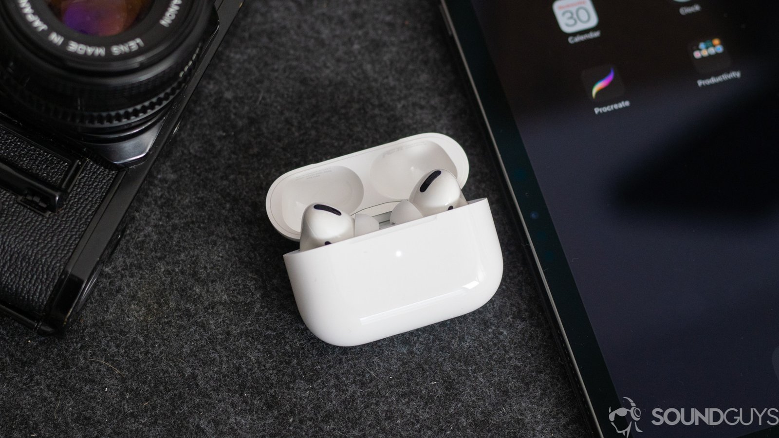 Tai nghe Apple AirPods Pro trong hộp sạc bên cạnh iPhone, để so sánh với Sennheiser Momentum True Wireless 2.