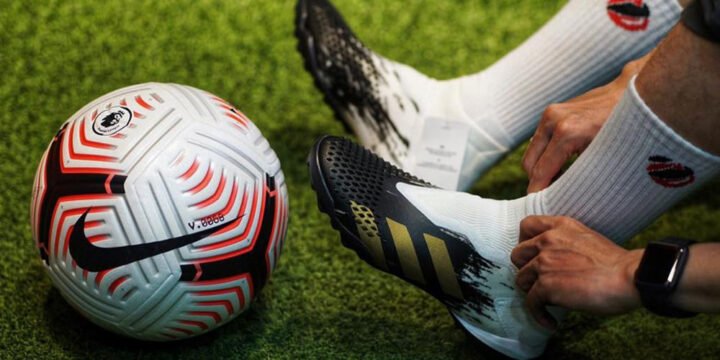 Cầu thủ kiểm tra đôi giày đá bóng bị bẩn trước khi ra sân