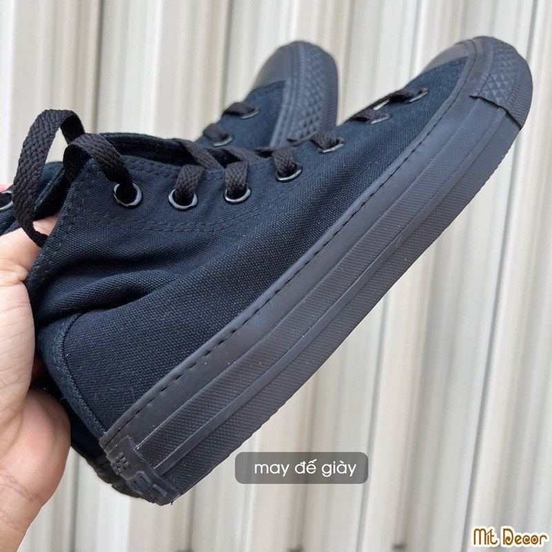 Thợ sửa giày chuyên nghiệp đang khâu may một đôi giày thể thao