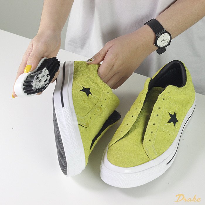 Áp dụng dung dịch vệ sinh chuyên dụng lên vết bẩn cứng đầu trên giày sneaker da lộn.