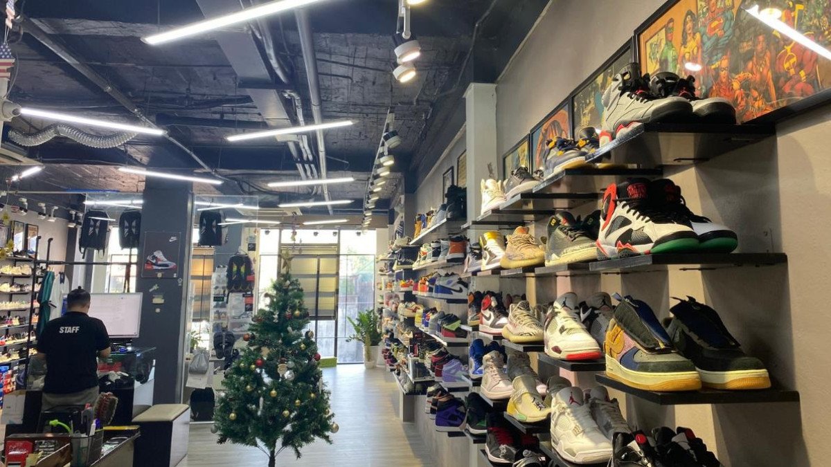 Bên trong cửa hàng Authentic Shoes ở Hà Nội, khách hàng đang ngắm nhìn và lựa chọn các mẫu giày thể thao New Balance và các thương hiệu khác trên những kệ trưng bày hiện đại.