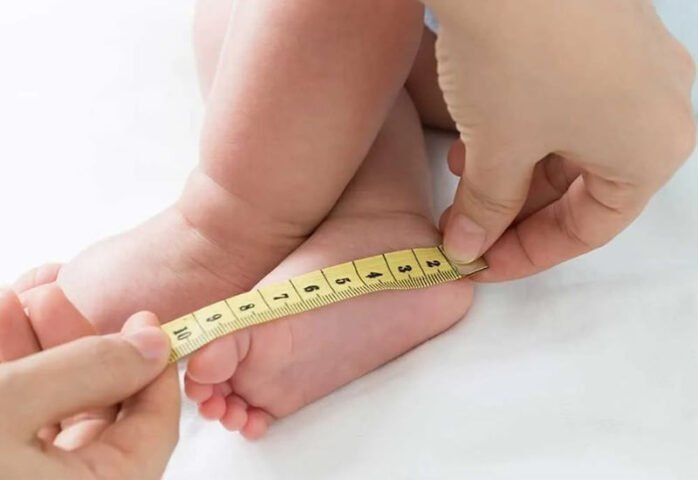 Bố mẹ đo chiều dài bàn chân bé sơ sinh để chọn đúng size giày