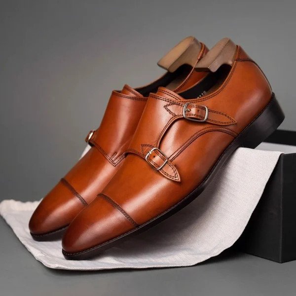 Cận cảnh đôi giày Monk Strap màu nâu với khóa kim loại vàng, thể hiện sự sang trọng và tinh tế cho quý ông