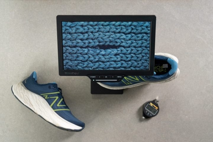 Cận cảnh vật liệu thân giày New Balance Fresh Foam X More v4 dưới kính hiển vi, cho thấy cấu trúc dệt chặt chẽ.