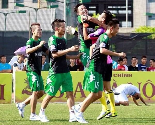 Cầu thủ bóng đá di chuyển nhanh trên sân cỏ nhân tạo.