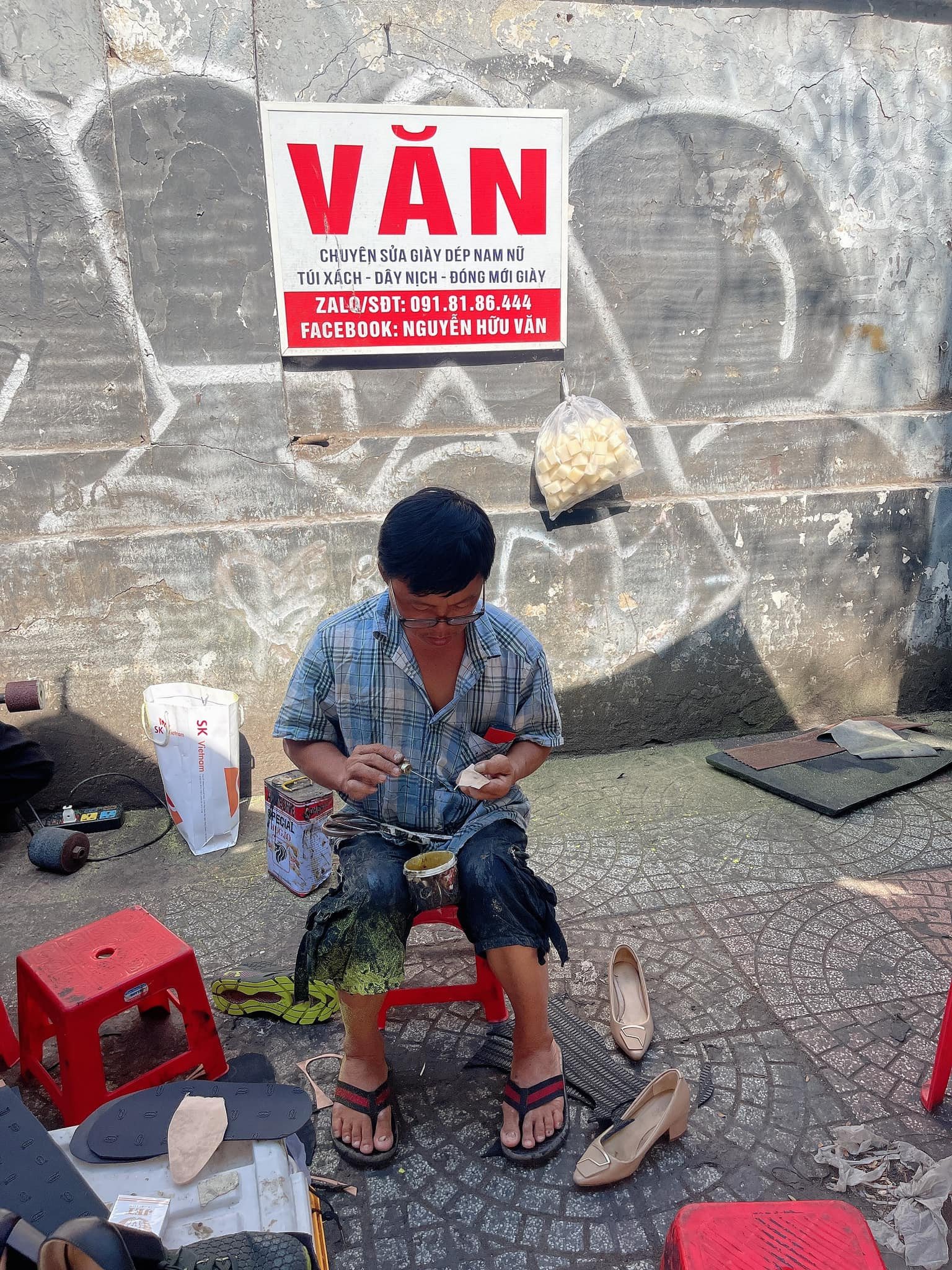 Chú Văn, thợ sửa giày kinh nghiệm đang tỉ mỉ may vá giày da
