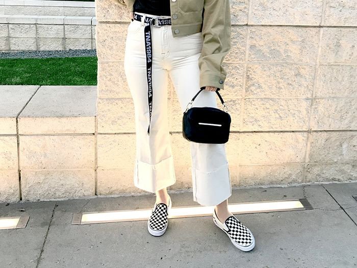 Cô gái diện quần jeans trắng và giày sneaker không dây nữ đen họa tiết