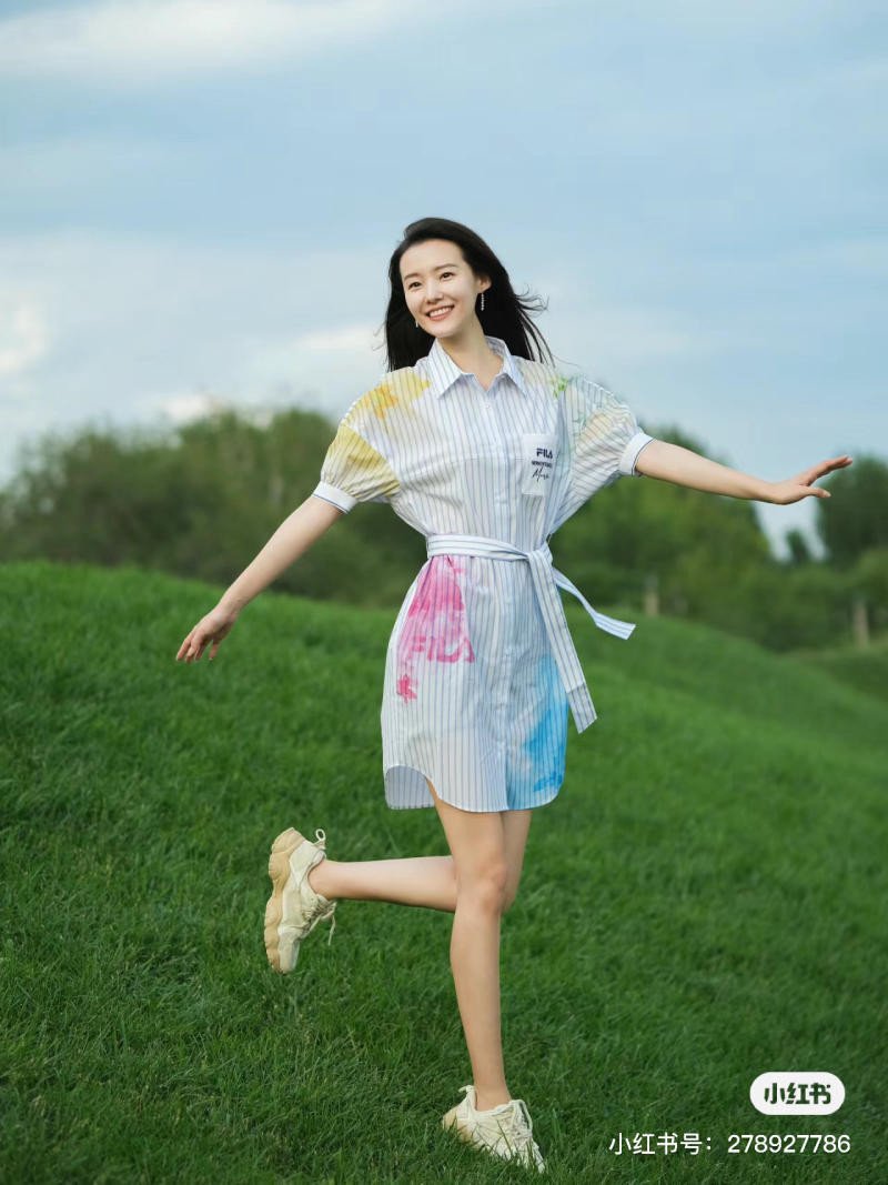Cô gái mặc váy sơ mi kẻ sọc và giày thể thao trắng