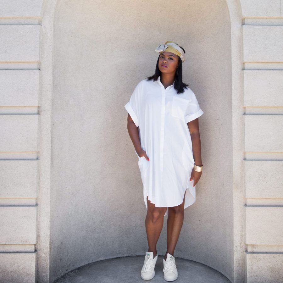 Cô gái mặc váy sơ mi trắng thắt eo kết hợp giày thể thao trắng tạo vẻ ngoài thanh lịch và hiện đại