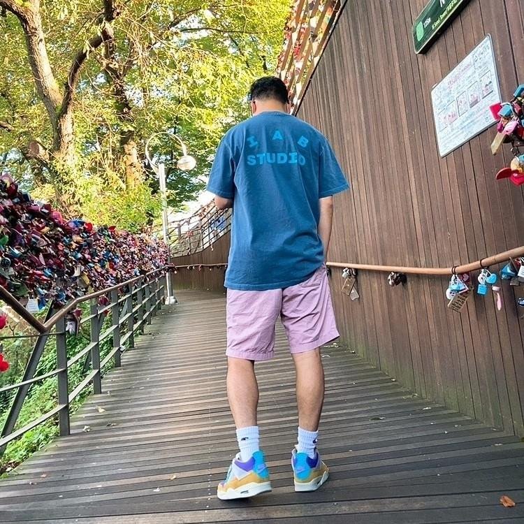 Cô gái trẻ trung phối Jordan 4 nữ với quần short jean và áo sơ mi caro