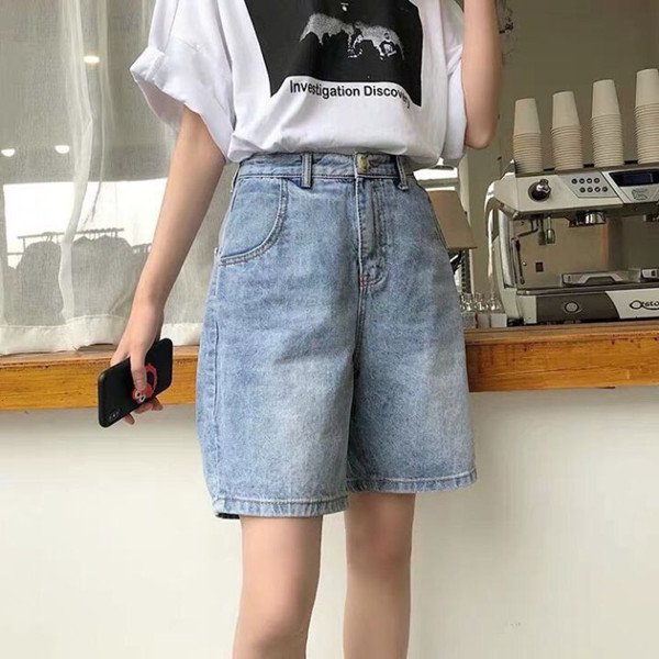 Cô gái với quần short jeans xanh nhạt rách và áo ba lỗ trắng thanh lịch
