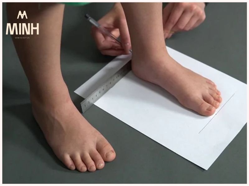 Đo bàn chân đặt lên giấy để xác định chiều dài phù hợp cho giày Onitsuka