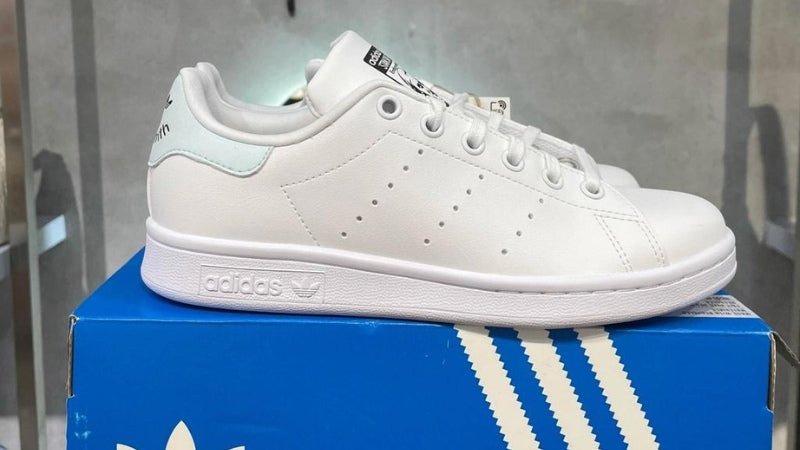 Đôi giày Adidas Superstar màu trắng với sọc đen, một trong các hãng giày thể thao kinh điển