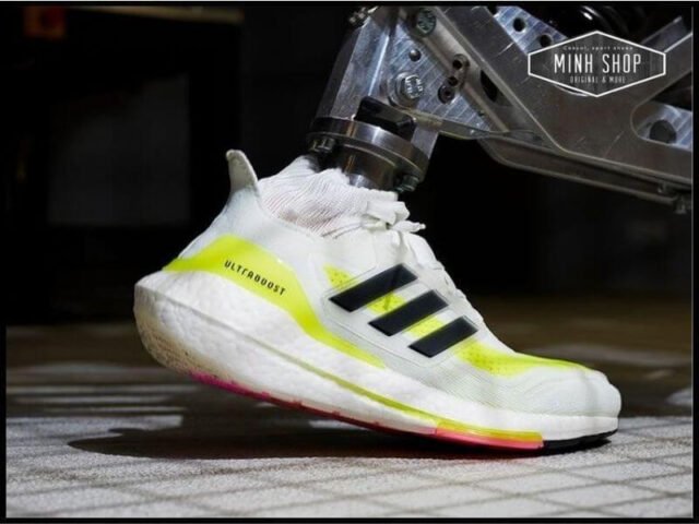 Đôi giày Adidas Ultra Boost màu đen và trắng trên nền gỗ, minh họa cách chọn size giày Ultra Boost