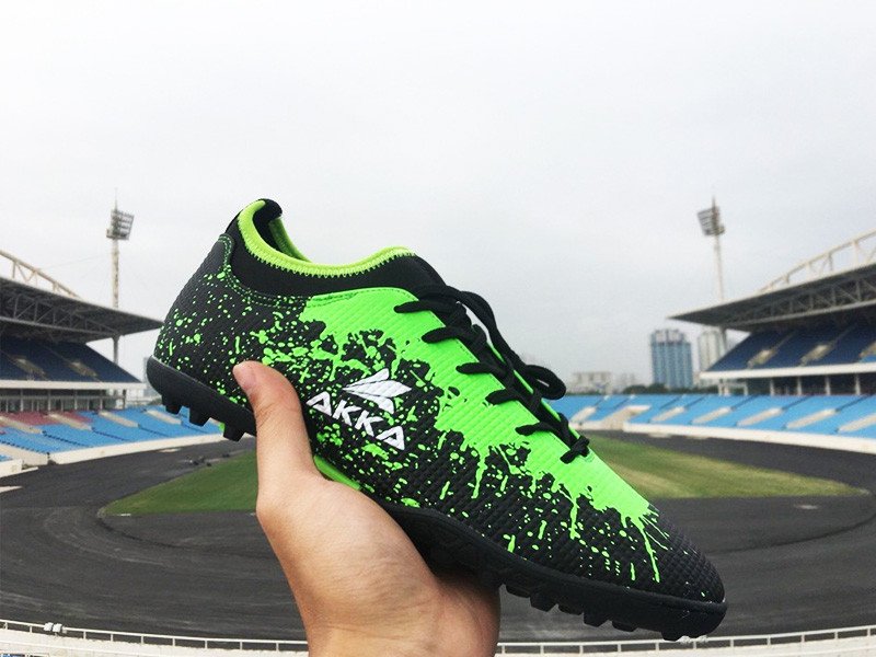 Đôi giày đá banh đang được cầm trên tay, cho thấy sự vừa vặn