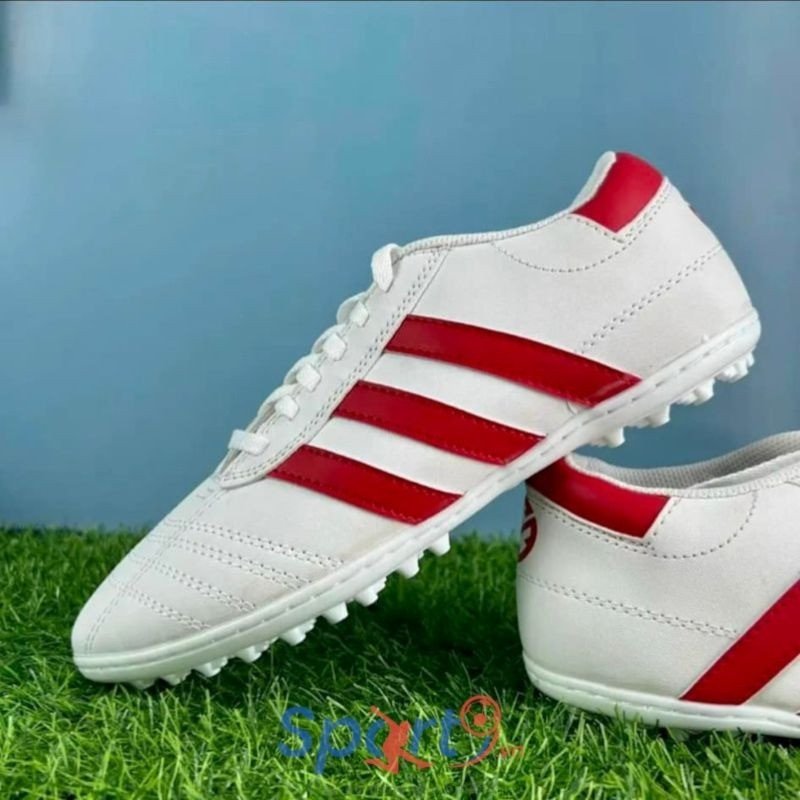 Đôi giày đá bóng 3 sọc màu xanh dương trên sân