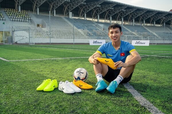 Đôi giày đinh TF màu đen vàng chuyên dụng cho sân cỏ nhân tạo.