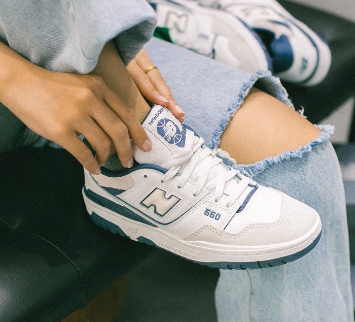 Đôi giày New Balance 550 trắng xanh đặt cạnh nhau, khoe chi tiết đế giày New Balance