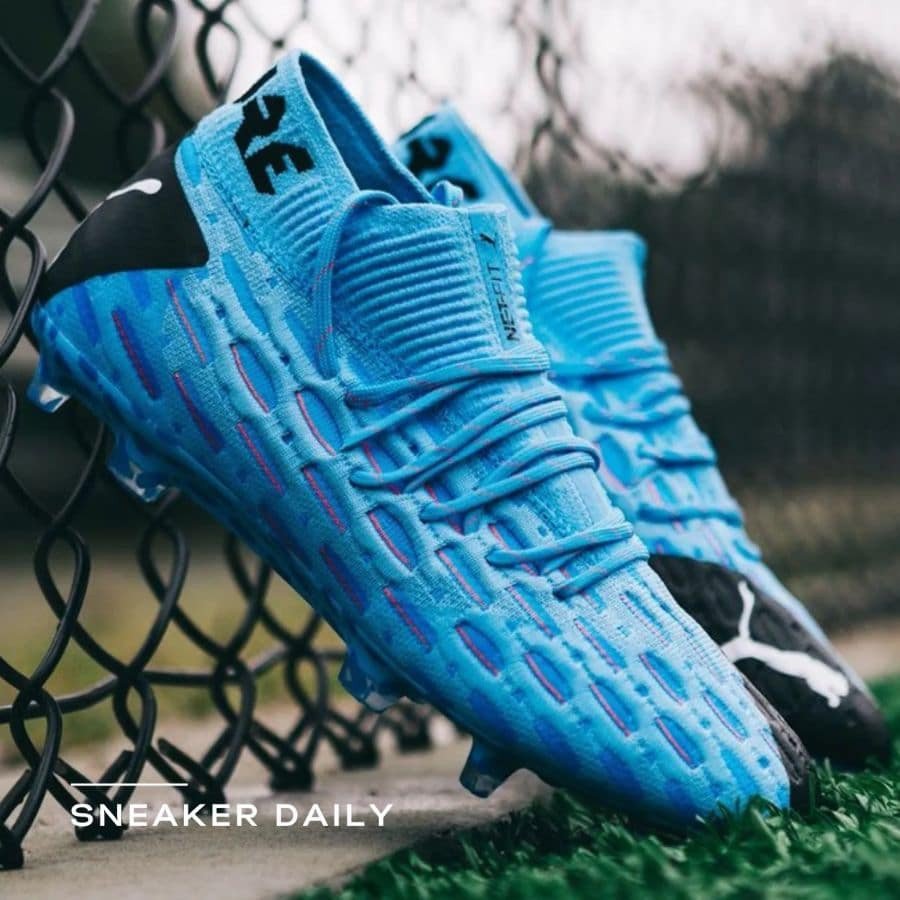 Đôi giày thể thao bóng đá với đinh tán dưới đế, màu đen xanh