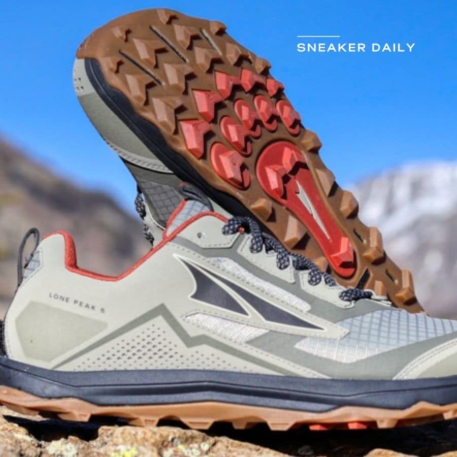 Đôi giày thể thao chạy địa hình với đế gai chắc chắn, màu xám cam