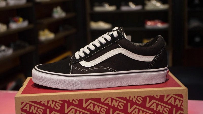 Đôi giày Vans Old Skool màu đen với sọc trắng biểu tượng, gắn liền với văn hóa đường phố và thương hiệu giày Vans