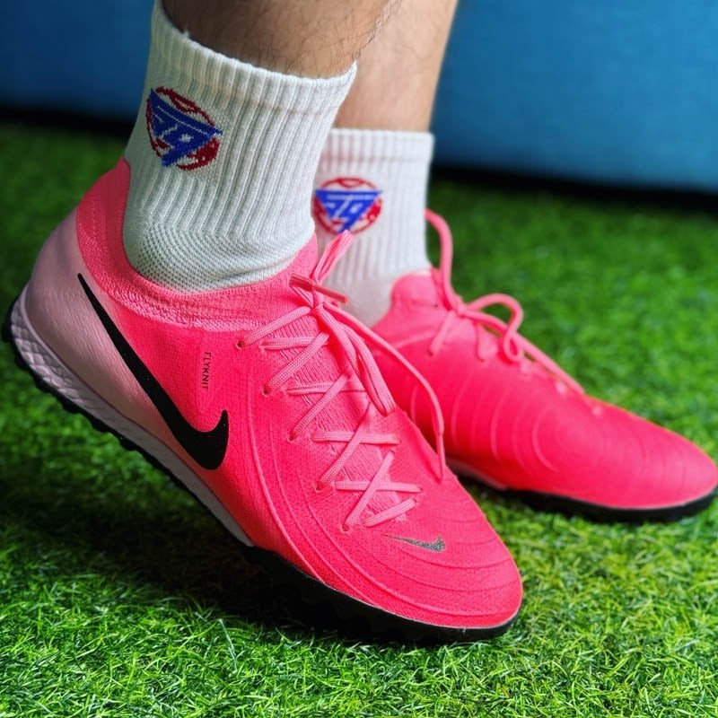 Giày đá bóng Nike Phantom GX 2 Pro TF màu hồng, với upper Flyknit ôm chân và hỗ trợ kiểm soát bóng cho chân bè.