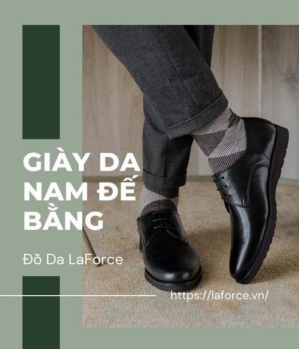 Giày lười nam đế bằng màu đen với đường may tinh xảo trên nền gỗ