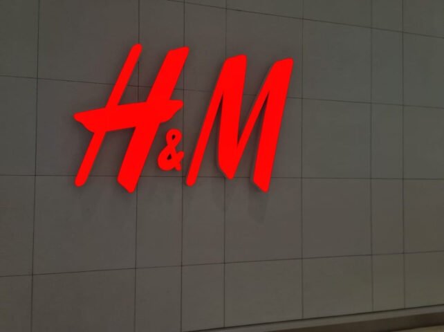 Hình ảnh bên ngoài một cửa hàng H&M với logo nổi bật, nơi có thể tìm thấy nhiều loại giày dép, bao gồm cả giày H&M cho bé