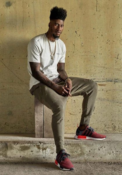 Hình ảnh cận cảnh một đôi giày Adidas NMD màu xám với đế Boost và các plug màu sắc, thể hiện sự đổi mới liên tục