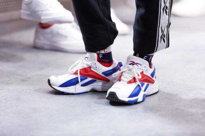 Hình ảnh logo Reebok và một đôi giày thể thao Reebok chính hãng, biểu tượng của thương hiệu.