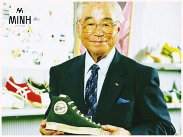 Logo thương hiệu Onitsuka Tiger trên nền xanh, đại diện cho lịch sử và chất lượng của thương hiệu
