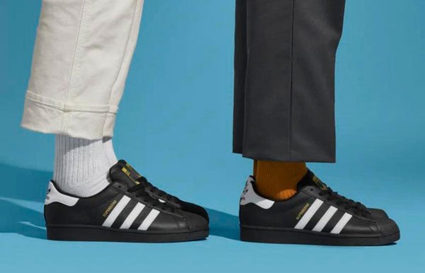 Một đôi giày Adidas Superstar màu trắng với sọc đen truyền thống, phối đồ tinh tế và sành điệu