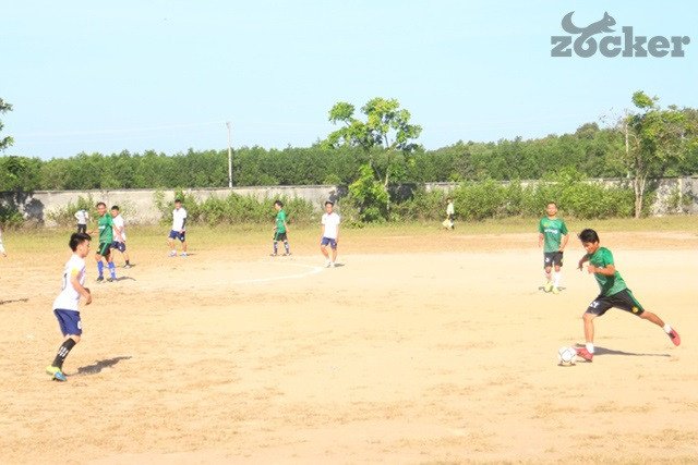 Một đôi giày đá bóng đinh dăm TF màu sắc nổi bật đặt trên mặt sân đất có cỏ, tượng trưng cho sự lựa chọn phù hợp cho sân đất.