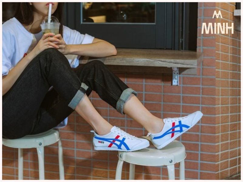 Một người phụ nữ đang thử một đôi giày màu trắng tại cửa hàng, chân đặt trên một bục