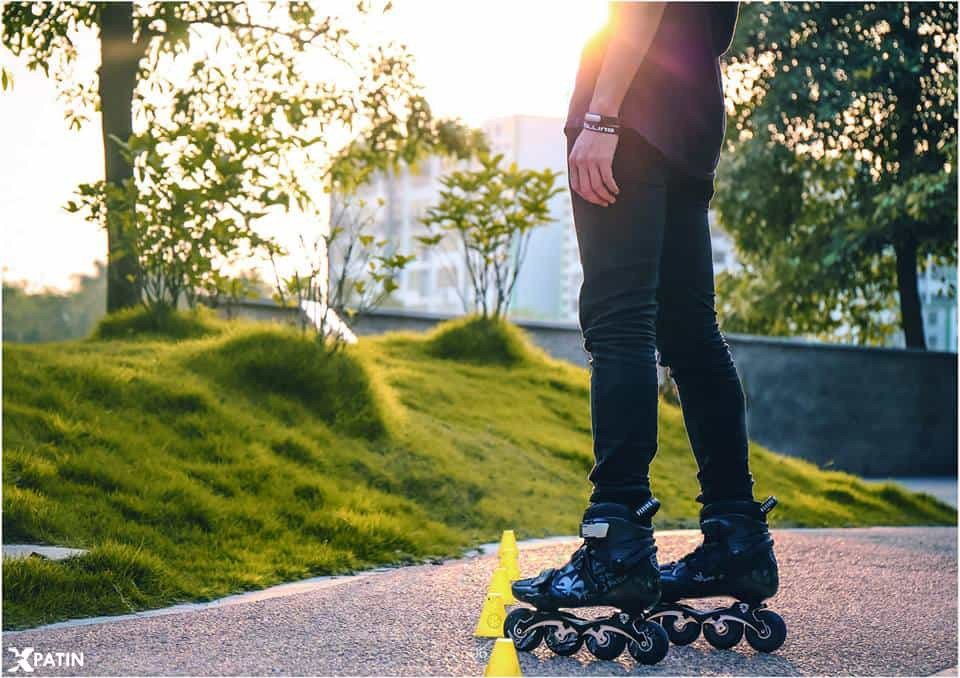 Một vận động viên người lớn đang trình diễn kỹ thuật với giày patin một hàng bánh dọc