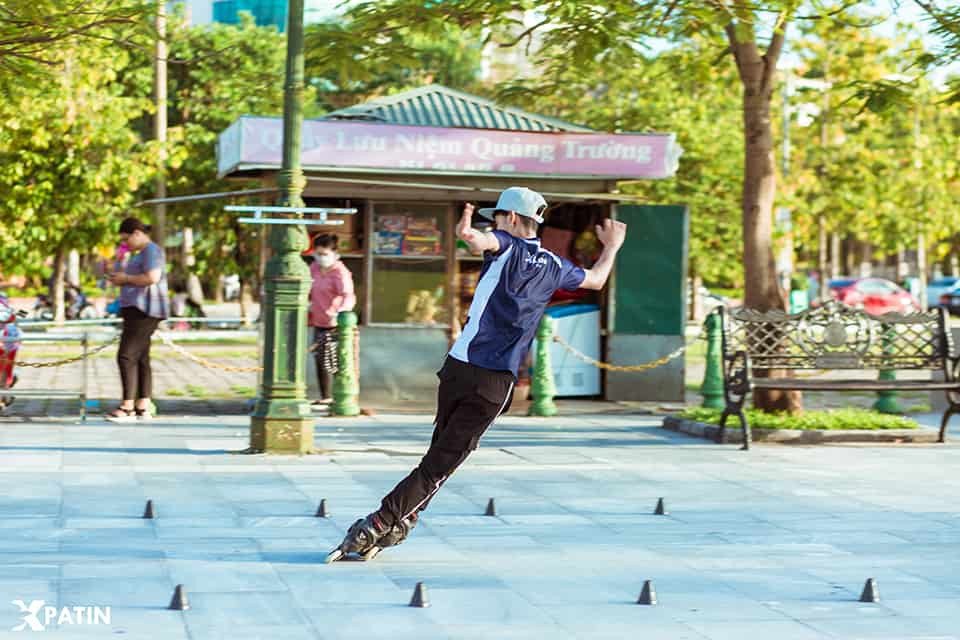 Người chơi thực hiện kỹ thuật trượt slalom với giày patin một hàng bánh
