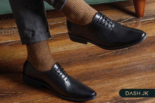Người đang đo chiều dài bàn chân bằng thước và bút chì