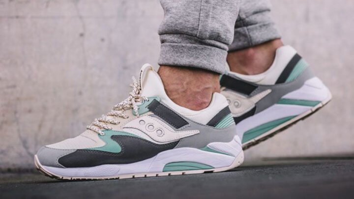 Người mẫu cầm đôi giày Saucony, minh họa cách chọn bảng size giày Saucony phù hợp.