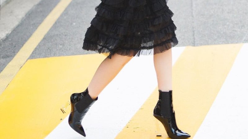 Người mẫu mặc chân váy xòe denim kết hợp boots cao cổ cá tính